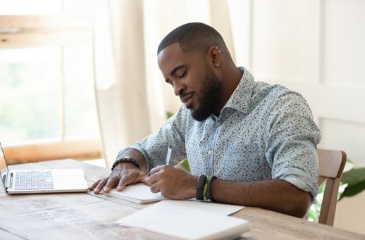 focused-african-man-student-freelancer-making-notes-studying-with-picture-id1170519330